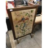 An early 20th Century oak framed firescreen with hand-embroidered insert