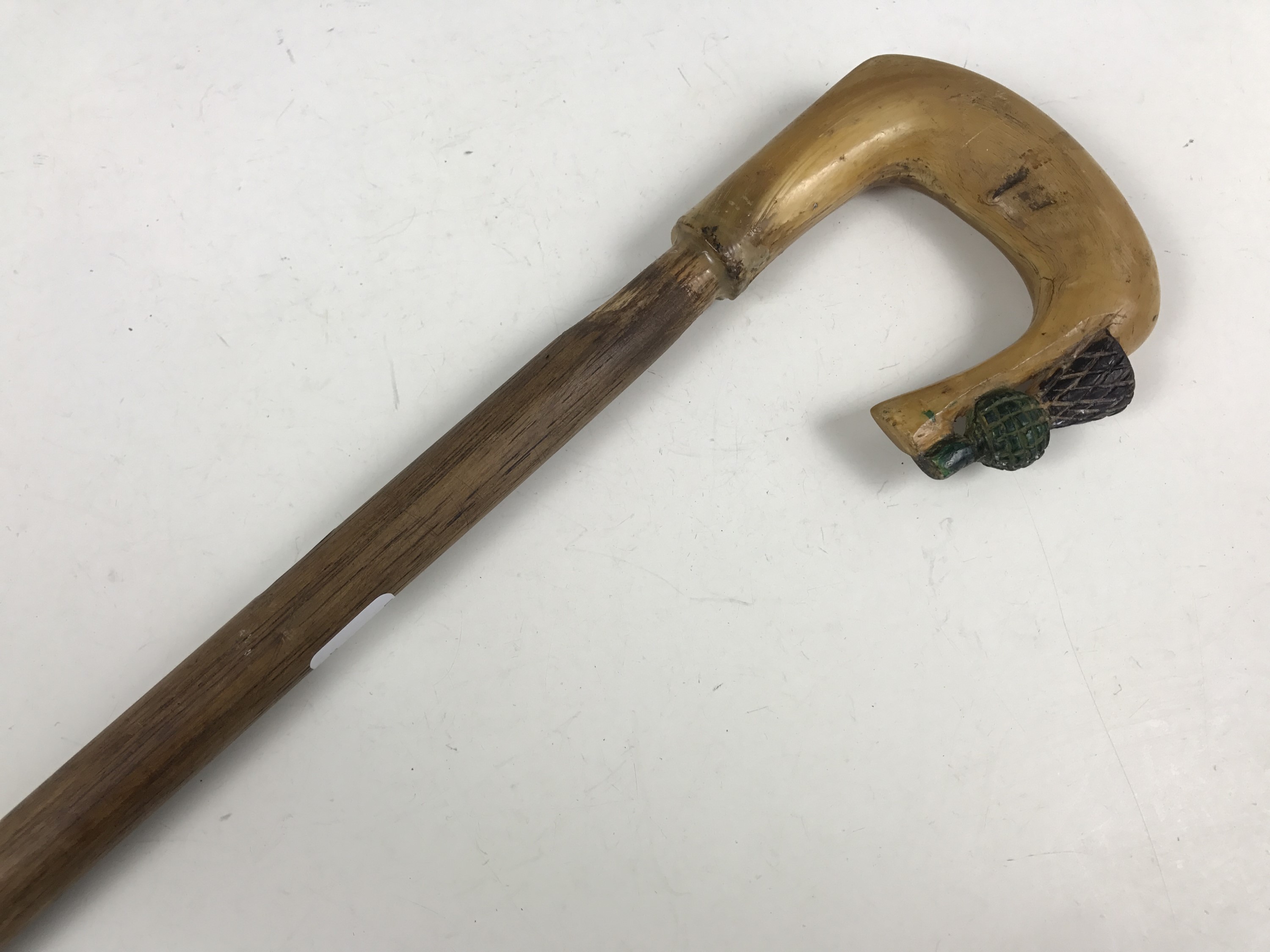 A walking cane with carved horn thistle terminal