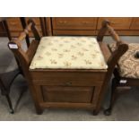 An oak piano stool with padded and hinged top