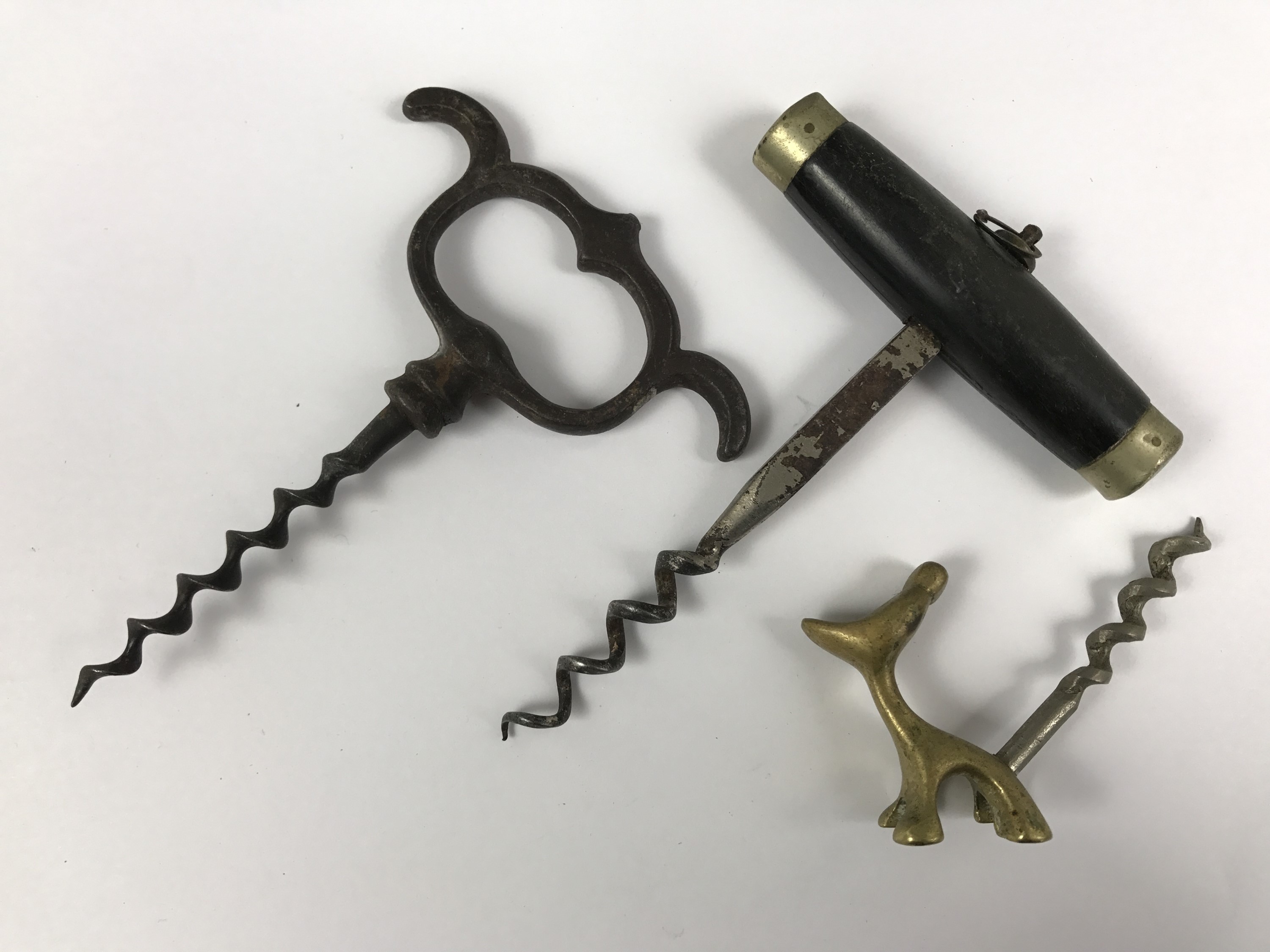 Three corkscrews including one with an Art Deco style cast-brass handle modelled as a dog