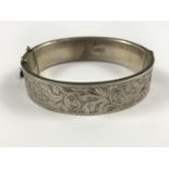 A George VI silver hinged bangle, having a foliate engraved face, Chester, 1948