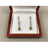 A pair of peridot, pearl and precious yellow-metal pendant earrings, having a pellet-form stud above