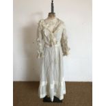 A late Victorian lady's two-piece dress, of ivory wool crepe with satin-stitched polka dots, the