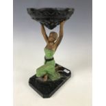 An inter-War Art Deco figural table lamp, modelled as a kneeling female holding aloft a torch (shade