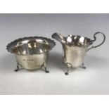 A George V silver sugar bowl and cream jug, each having a cusped and everted rim, E S Barnsley & Co,