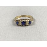 A vintage sapphire and diamond dress ring, comprising three round cut sapphires, the largest of