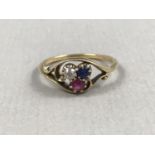 A vintage three-stone dress ring, comprising round-cut diamond, ruby and sapphires, twist-set in a