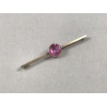 An early 20th Century pink tourmaline bar brooch, the circular cut stone of approximately 8.5mm