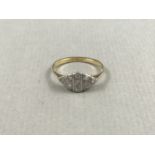 A 1930s diamond ring, the lenticular white-metal face being divided into geometric cells and