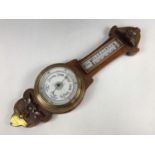 An early 20th Century carved oak banjo barometer bearing a brass plaque with engraved presentation