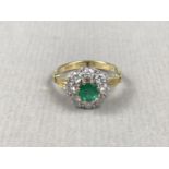 An emerald and diamond dress or engagement ring, comprising a circular emerald of approximately .5