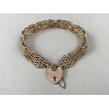 An early 20th Century yellow-metal gate-link bracelet with heart shaped padlock clasp, stamped