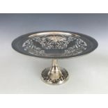 A George V silver table centrepiece, the shallow dish reticulated with whiplash fronds and urns,