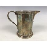 A George V silver milk jug, of faceted cylindrical form, with moulded rim, Docker & Burn Ltd,