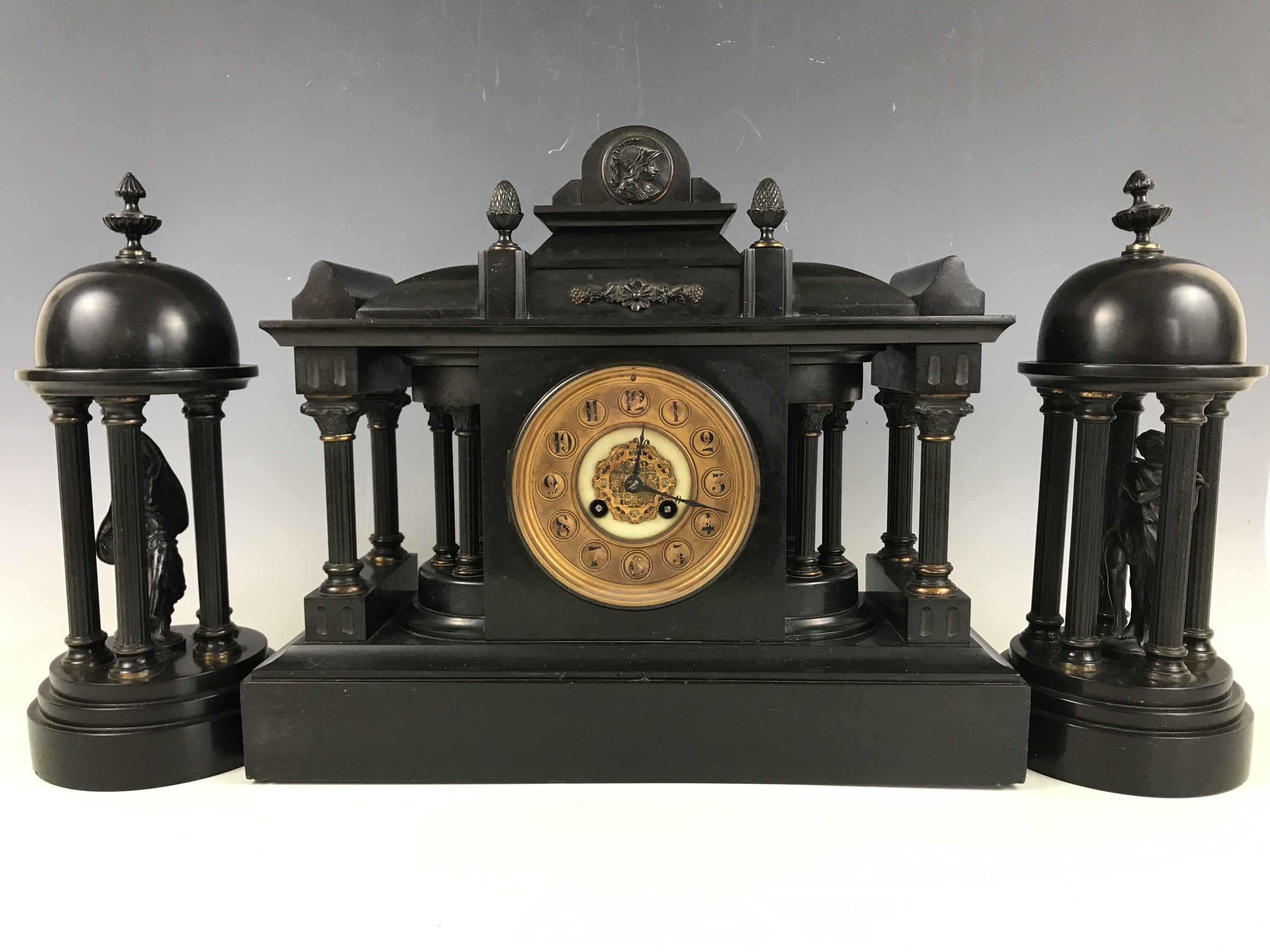 A 19th Century black slate mantle clock garniture, of architectural form, clock 35 cm high