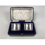 A cased pair of George V silver napkin rings, having geometric floral borders, SW Smith & Co,