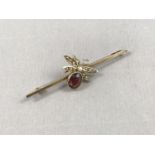 An early 20th Century bar brooch surmounted by a seed pearl and garnet set insect, the latter having