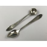 A pair of Indonesian Yogya white metal mustard / salt spoons, the planar stems bearing typical