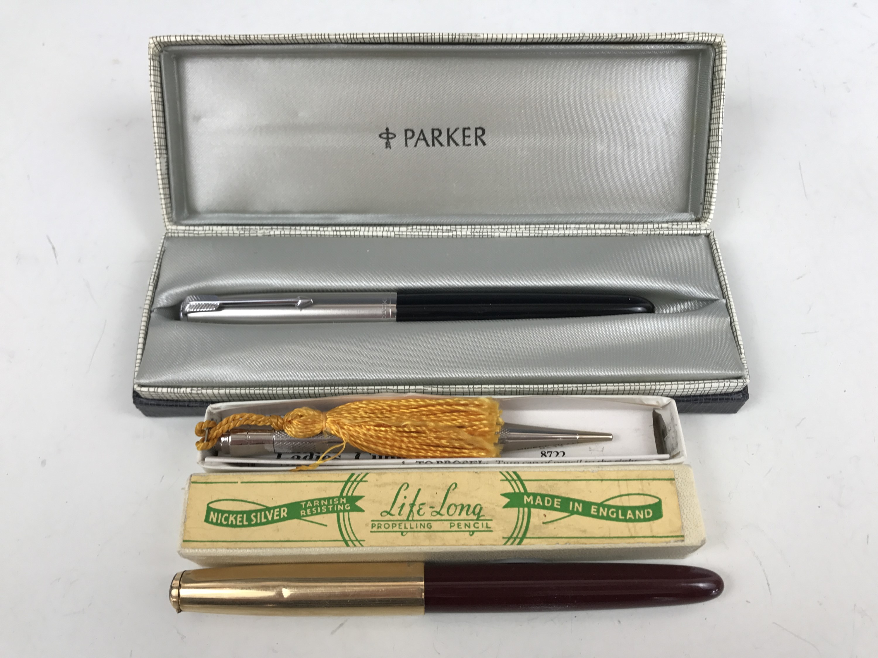 A cased Parker fountain pen together with a "Life-Long" propelling pencil and one other pen