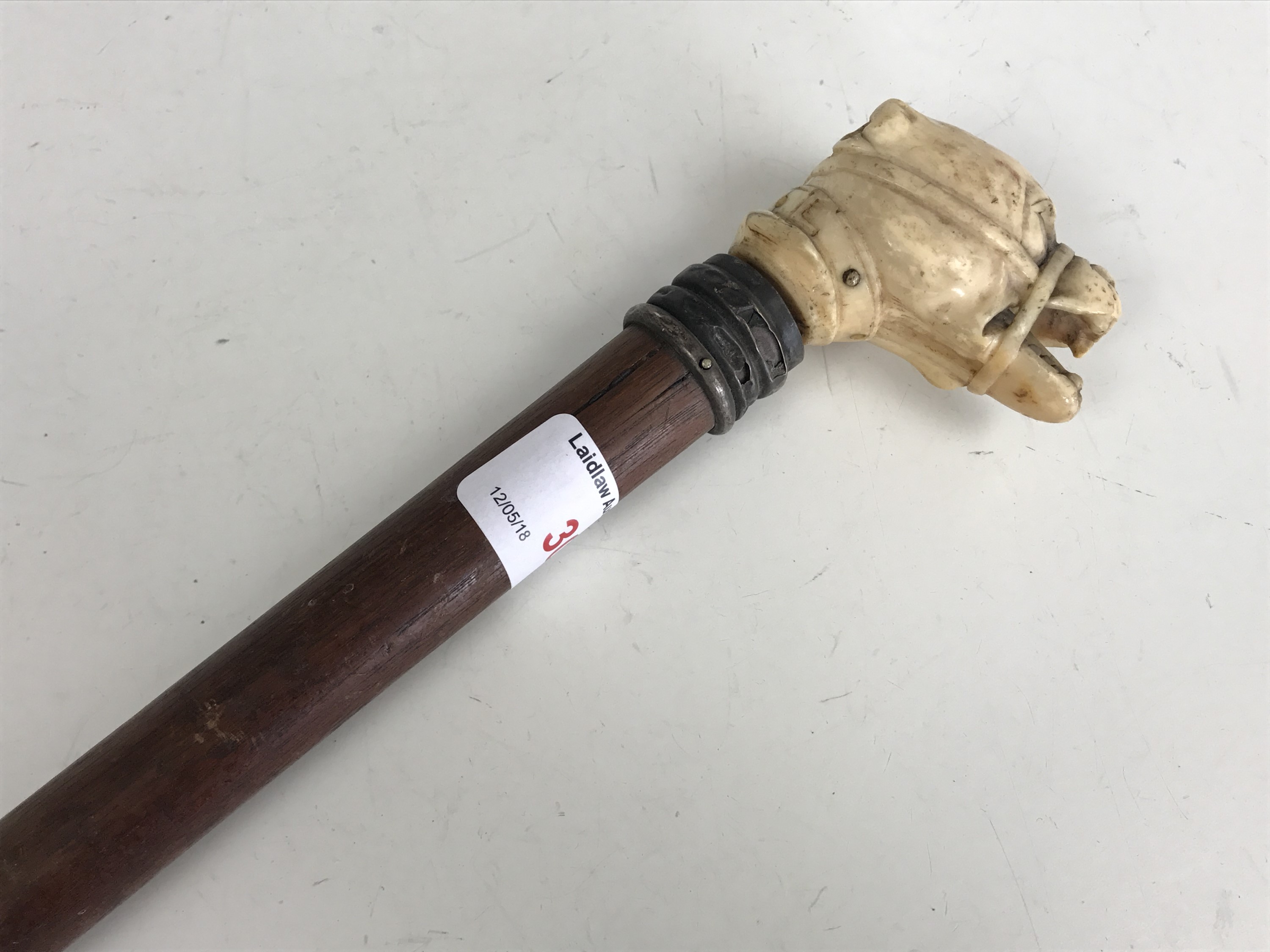 A Victorian walking cane with ivory pommel carved as a snarling dog's head
