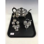 An electroplate teapot together with two cruet sets and a heron bell