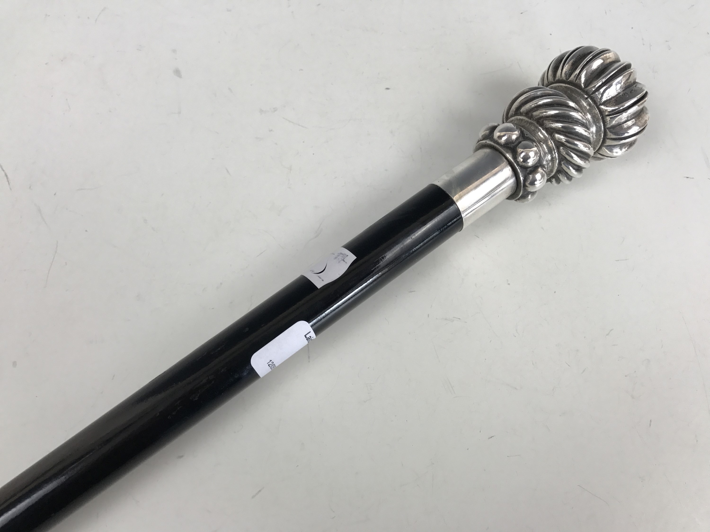 A contemporary ebonised walking cane with electroplate pommel