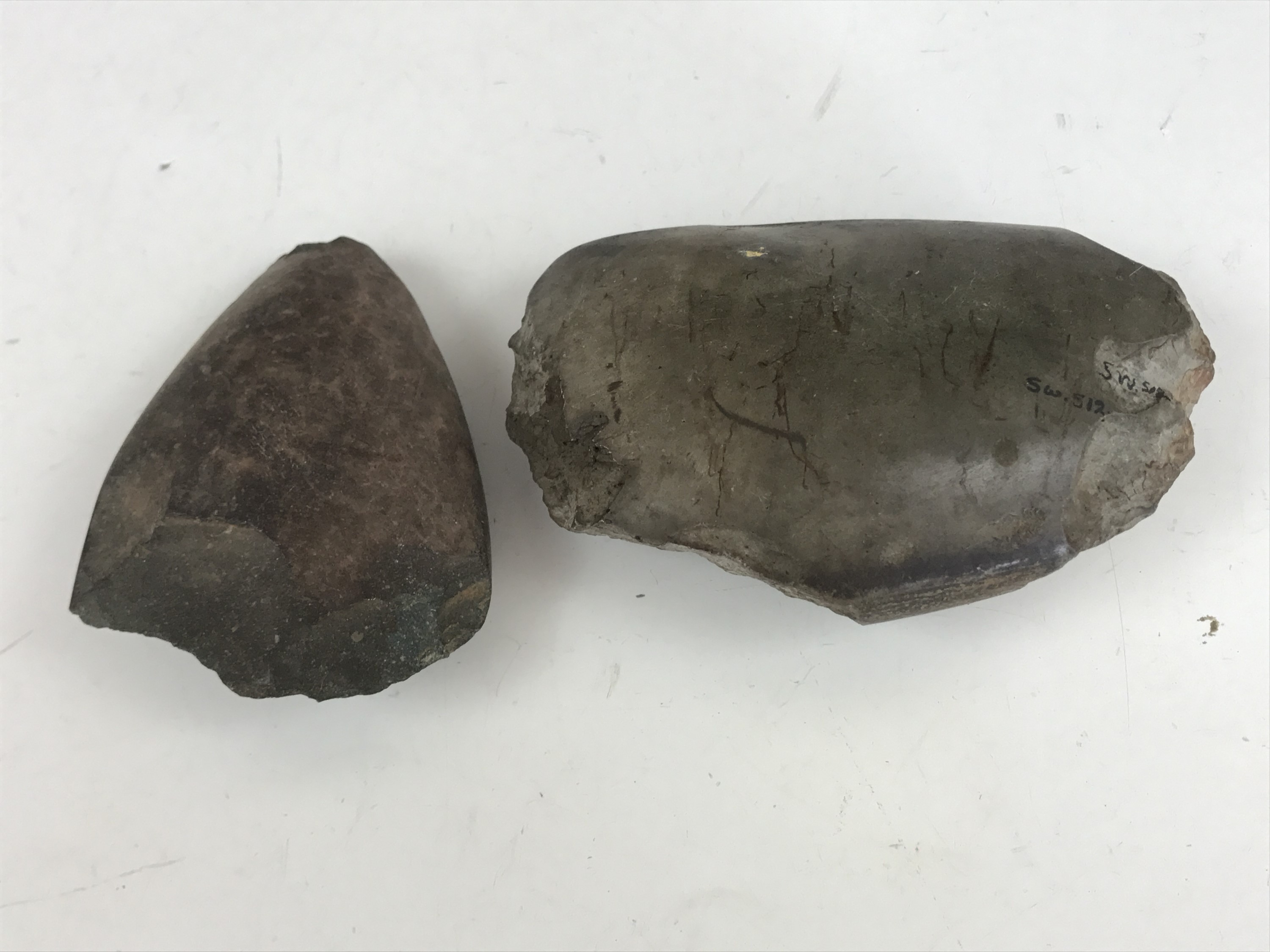 Two Neolithic / Bronze Age polished stone hand axes, one bearing old collection inventory number
