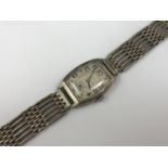 A 1920s silver-cased wrist watch having a tonneau shaped case and silver bracelet strap