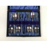 A cased set of electroplate apostle spoons and tongs