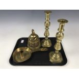 A pair of Victorian brass candlesticks, 29 cm together with a brass bell and a brass candlestick