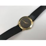 A lady's Gucci gold plated wristwatch, having a quartz movement, black dial and Roman numerals to