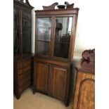 A Victorian mahogany floor-standing corner display cabinet, the glazed upper section having a swan-