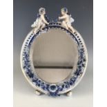 A Meissen style porcelain mirror, having a moulded frame with applied blue-and-white flowers,