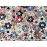 A Victorian patchwork quilt, wrought in a variant 'grandmother's flower garden' pattern, within a