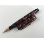 A 1930s Parker Duofold Senior fountain pen, in brown / burgundy pearl, having 14K gold nib and