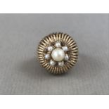 A vintage yellow-metal and pearl cocktail ring, having a central flower-head cluster of pearls,