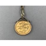 A 1974 gold Sovereign in a 9ct gold pendant mount on a yellow-metal Figaro link bracelet, 15.7g