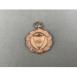 A George V 9ct gold rugby football prize medallion, engraved verso 'Aspatria R.U.F Club / Seven a