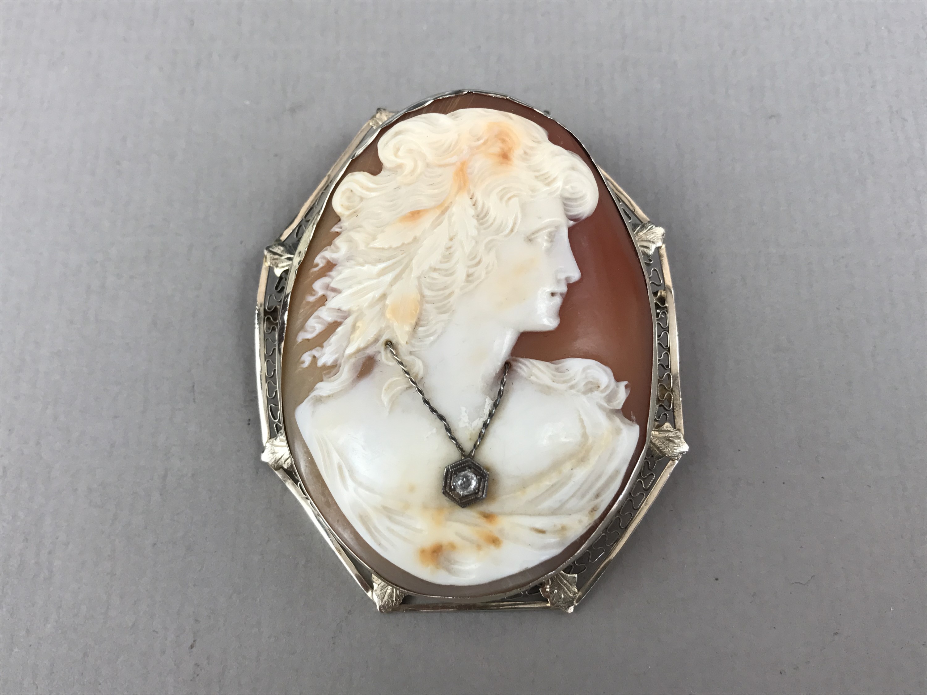 An Edwardian diamond and carved cameo brooch, bearing the profile of a young maiden with flowing