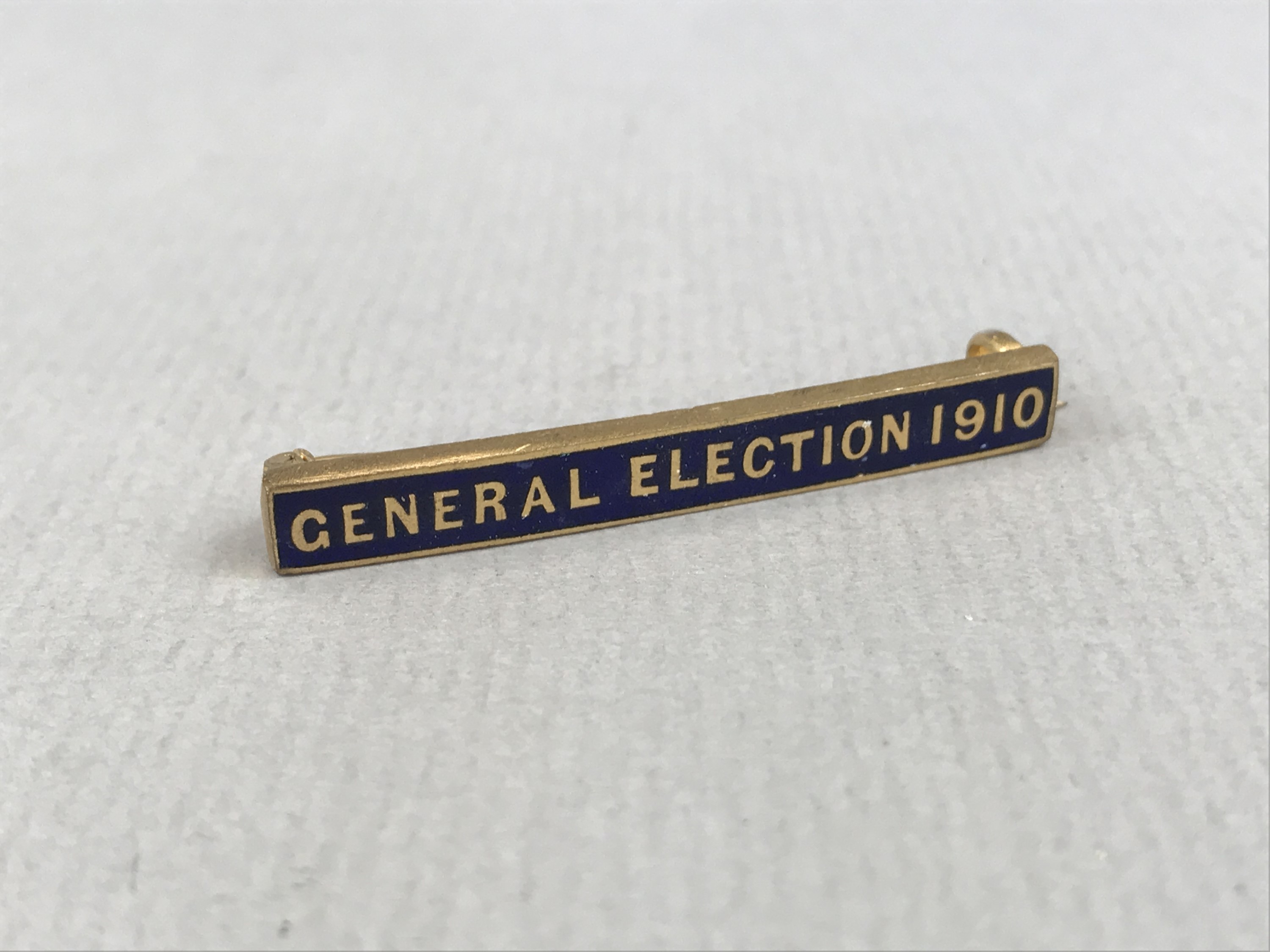 A "General Election 1910" rolled-gold and enamelled bar brooch, manufactured by Wolewis of