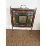 A late Victorian Aesthetic movement stained-glass and brass fire screen, the central hand-