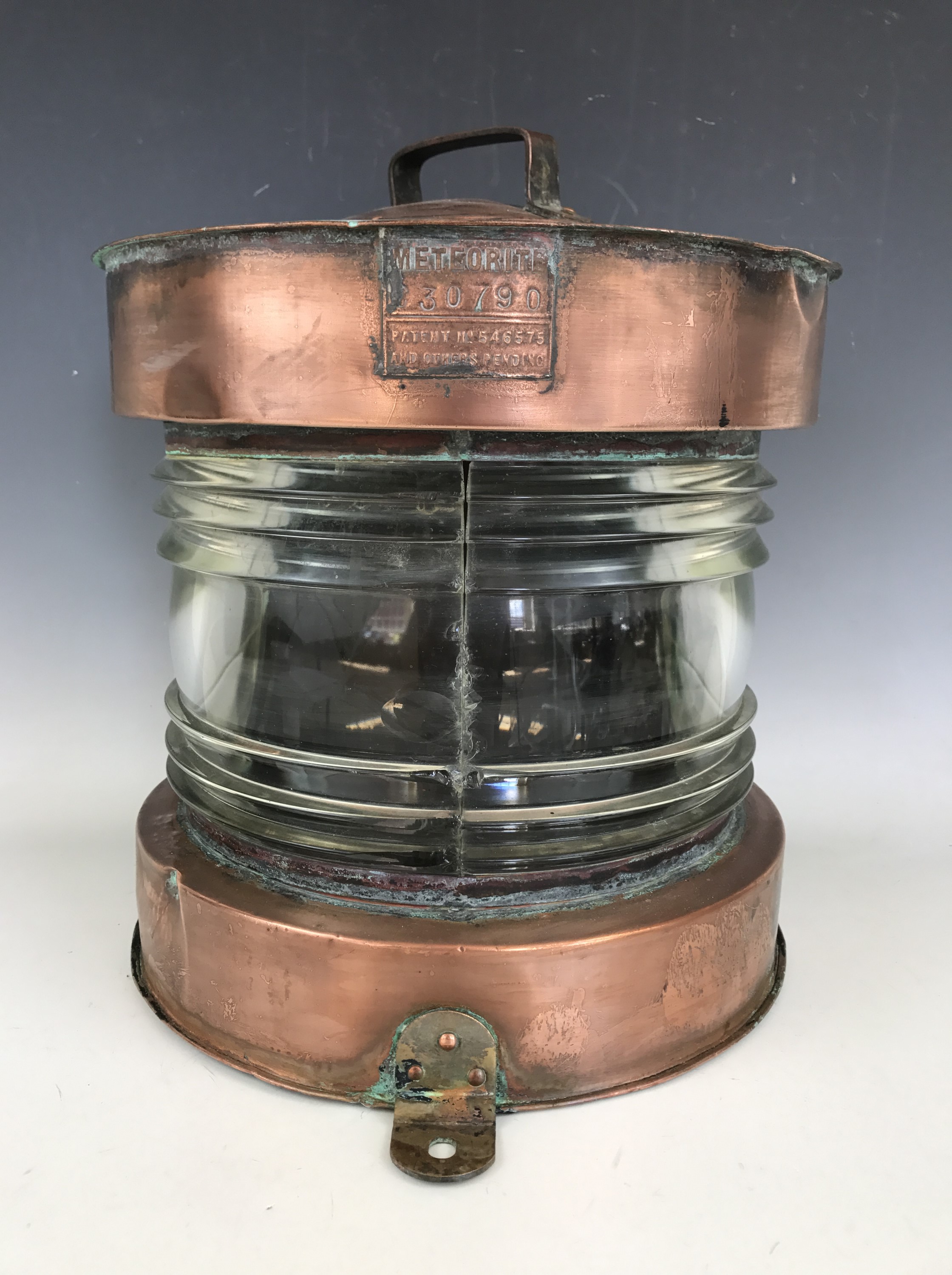A ship's large copper Meteorite ship's masthead lantern, having a bisected clear fresnel lens, 35