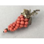 A 1930s novelty yellow-metal and coral brooch in the form of a bunch of grapes, tests as gold