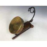 A wrought-iron and brass dinner gong, of scrolling form faced with copper foliage, late 19th / early