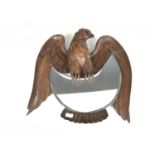 A late 19th / early 20th Century Black Forest carved wooden mirror modelled as an eagle grasping the