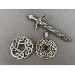 Two Scottish silver brooches, including one in the form of a sword, together with a silver Celtic