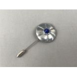 A Liberty of London lapis lazuli and pewter stick pin, in the form of a stylized flower head, with