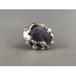 A Wiggers of Denmark Modernist amethyst cocktail ring, the mineral specimen held in a molten-