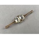 An Edwardian aquamarine and yellow-metal bar brooch, in an open arrangement, having two oval-cut