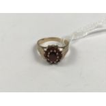 A 9ct gold and garnet dress ring, in a flower-head cluster arrangement over a radially-cut 9ct